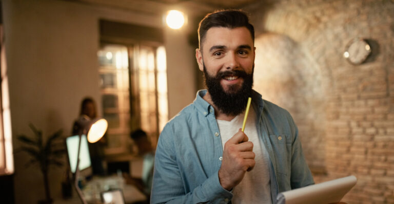 Checklist de meio de ano — empresário segurando tablet e caneta em escritório pronto para revisar obrigações antes de julho